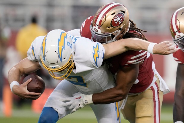 Chargers quarterback Easton Stick is sacked by San Francisco 49ers linebacker Fred Warner during the first half of a preseason NFL football game Friday, Aug. 25, 2023, in Santa Clara, Calif. (AP Photo/Godofredo A. Vásquez)