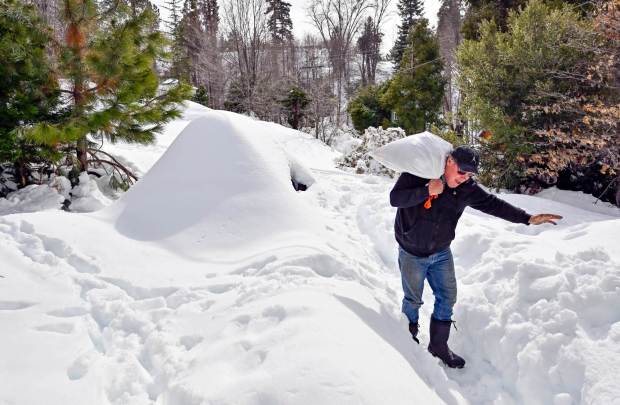Sean Devine works to get up the path to Sherrill Waton's home as he delivers food in Cedar Glen, CA, on Monday, March 6, 2023. (Photo by Jeff Gritchen, Orange County Register/SCNG)