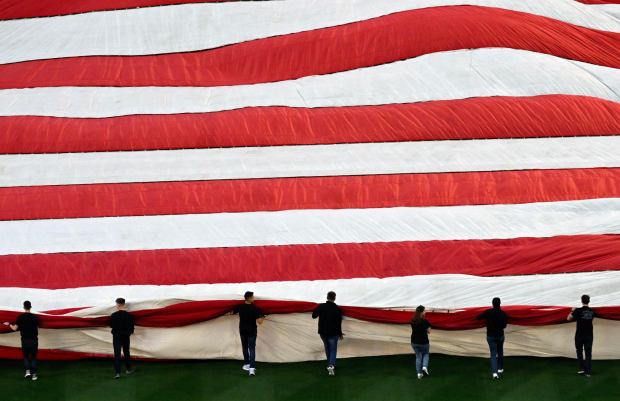 Active duty local military personnel unfurl a 150-foot by 300-foot American flag before the singing of "The Star-Spangled Banner." On Opening Day at Angel Stadium in Anaheim, CA, on Friday, April 7, 2023. (Photo by Jeff Gritchen, Orange County Register/SCNG)