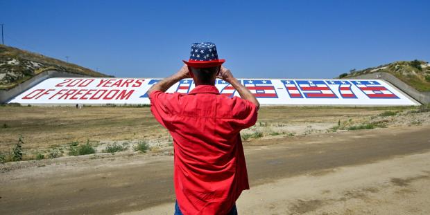 Rory Murray takes a picture of the Prado Dam Bicentennial Mural during a dedication ceremony in Corona, CA, on Friday, June 2, 2023. (Photo by Jeff Gritchen, Orange County Register/SCNG)