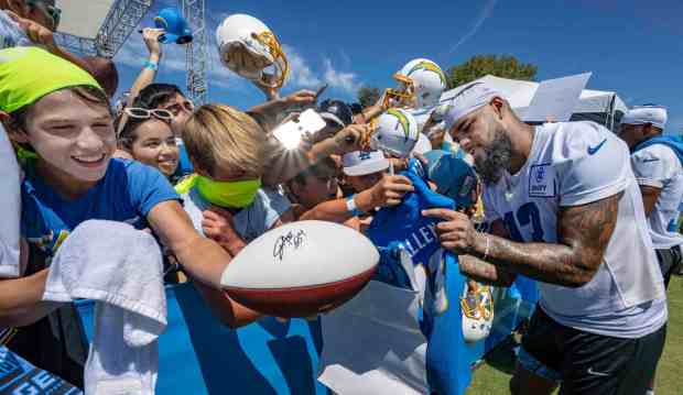 Keenan Allen, right, a wide receiver with the Los Angeles Chargers, signs autographs for fans following the first practice of training camp at the Jack R. Hammett Sports Complex in Costa Mesa on July 26, 2023. (Photo by Mark Rightmire, Orange County Register/SCNG)