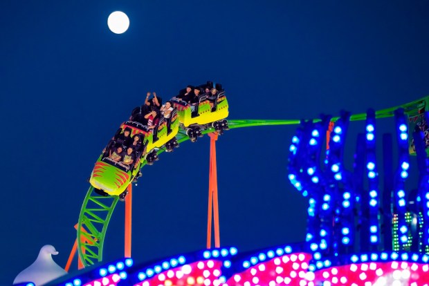 Fair goers ride the Raptor Coaster beneath the rising moon as night falls over the OC Fair at the OC Fair & Event Center in Costa Mesa on Sunday, July 30, 2023. (Photo by Leonard Ortiz, Orange County Register/SCNG)