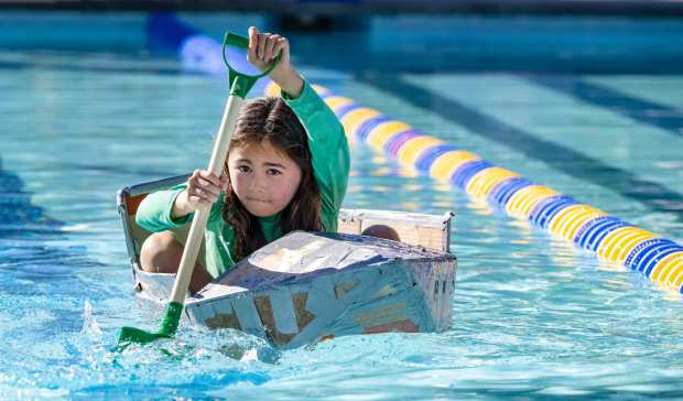Violet Lee, 9, concentrates as she paddles her boat across the pool as the city of Mission Viejo hosts the Cardboard Boat Derby at the Marguerite Aquatics Complex in Mission Viejo on Saturday, August 26, 2023. The teams had one hour to build a boat of cardboard and duct tape and then one person paddled the boat the length of a pool in a race with the fastest time winning. (Photo by Mark Rightmire, Orange County Register/SCNG)