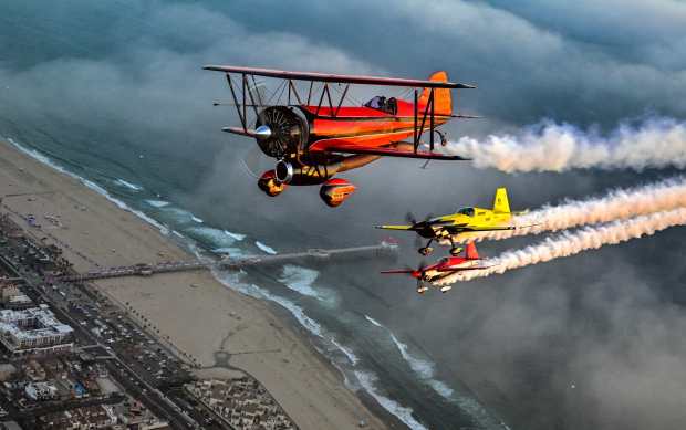 Sammy Mason, flying the Edge 540, left, Mike Goulian, flying an Extra 330, center, and Jarrod Lindeman, in the Jet Waco biplane, fly over Huntington Beach, CA, in preparation for the Pacific Airshow on Thursday, September 28, 2023. (Photo by Jeff Gritchen, Orange County Register/SCNG)