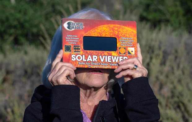 Looking through a solar viewer, Linda Akins of Laguna Woods watches the annular solar eclipse at Caspers Wilderness Park in San Juan Capistrano early Saturday morning, October 14, 2023. At the height of the eclipse the moon covered approximately 70 percent of the sun's surface. (Photo by Mark Rightmire, Orange County Register/SCNG)