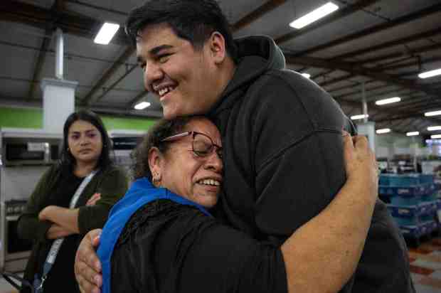 David Saldana is embraced by his grandma, Martha Lara, after not seeing her for ten years. Twenty-five families from Mexico were reunited with relatives in Fountain Valley on Tuesday, October 24, 2023. Curacao and Fundacion Jalisco USA sponsored the event. Some family members had not seen their loved ones for more than two decades. (Photo by Mindy Schauer, Orange County Register/SCNG)