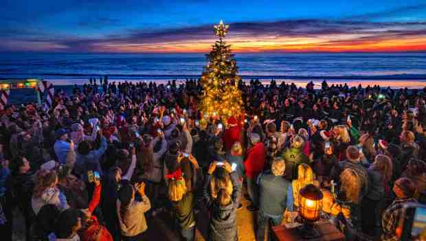As the tree lights are turned on, hundreds of people gather around as the Christmas tree on the beach at Crystal Cove State Park in Newport Beach as the Crystal Cove Conservancy hosts its annual holiday bazaar and tree lighting ceremony on Saturday, December 2, 2023. (Photo by Mark Rightmire, Orange County Register/SCNG)
