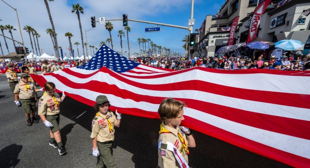 Orange County Boy Scouts carrying a large American flag make the turn from Pacific Coast Highway on to Main Street in Huntington Beach during the 119th Independence Day Parade on Tuesday, July 4, 2023. (Photo by Mark Rightmire, Orange County Register/SCNG)