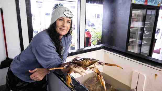 Shala Mansur-O'Keefe, owner of Jon's Fish Market, holds a Dungeness crab at the market and restaurant at the harbor in Dana Point, CA on Friday, December 30, 2022. (Photo by Paul Bersebach, Orange County Register/SCNG)