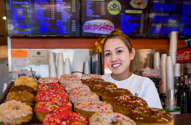 Linda Thach of B&B Donuts displays a selection of glazed sprinkles and French cruller donuts in Fullerton on Wednesday, Jan. 3, 2024. B&B Donuts half-mile south of the Fullerton Train Station. (Photo by Leonard Ortiz, Orange County Register/SCNG)