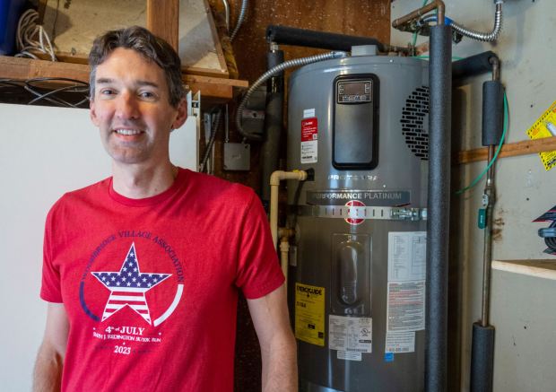 Steven Allison of Irvine stands next to the heat pump water heater in the garage of his home on Thursday, December 7, 2023. Allison's home is solar powered and everything in the home runs on electricity. He has even had the gas shut off to the house. (Photo by Mark Rightmire, Orange County Register/SCNG)