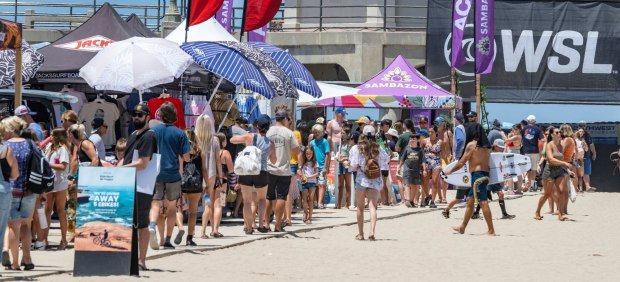 Surfing fans and beach goers walk past the many booths on the beach at the US Open of Surfing in Huntington Beach, on Tuesday, Aug. 1, 2023. (Photo by Mark Rightmire, Orange County Register/SCNG)