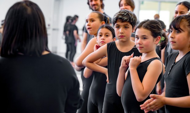 Students from The Wooden Floor, right, listen as Small Island Big Song performer Yun xe2x80x9cYumaxe2x80x9d Chien, left, answers questions during a master class in Santa Ana on Friday, Feb. 2, 2024. The Wooden Floor partnered with Chapman Universityxe2x80x99s Musco Center for the Arts to provide six master classes to all The Wooden Floor student, free of charge. Small Island Big Song is an artistic collective of singers, musicians, and dancers from island nations in the Indian and Pacific Oceans that perform their traditional dances and songs. Small Island Big Song will be performing at the Musco Center for the Arts on Feb. 3. (Photo by Leonard Ortiz, Orange County Register/SCNG)