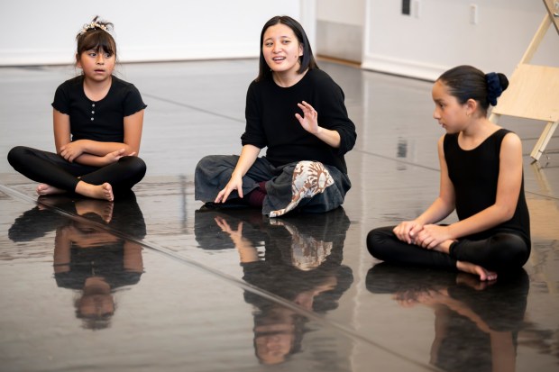 Small Island Big Song performer Yun xe2x80x9cYumaxe2x80x9d Chien, center, of Taiwan guides students from The Wooden Floor in a song during a master class in Santa Ana on Friday, Feb. 2, 2024. The Wooden Floor partnered with Chapman Universityxe2x80x99s Musco Center for the Arts to provide six master classes to all The Wooden Floor student, free of charge. ..Small Island Big Song is an artistic collective of singers, musicians, and dancers from island nations in the Indian and Pacific Oceans that perform their traditional dances and songs. Small Island Big Song will be performing at the Musco Center for the Arts on Feb. 3. (Photo by Leonard Ortiz, Orange County Register/SCNG)