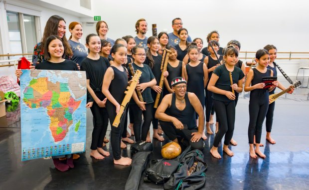 Performers with xe2x80x9cSmall Island Big Songxe2x80x9d pose for a photo with students at The Wooden Floor after a master class in song and dance in Santa Ana on Friday, Feb. 2, 2024. The Wooden Floor partnered with Chapman Universityxe2x80x99s Musco Center for the Arts to provide six master classes to all The Wooden Floor student, free of charge. Small Island Big Song is an artistic collective of singers, musicians, and dancers from island nations in the Indian and Pacific Oceans that perform their traditional dances and songs. Small Island Big Song will be performing at the Musco Center for the Arts on Feb. 3. (Photo by Leonard Ortiz, Orange County Register/SCNG)
