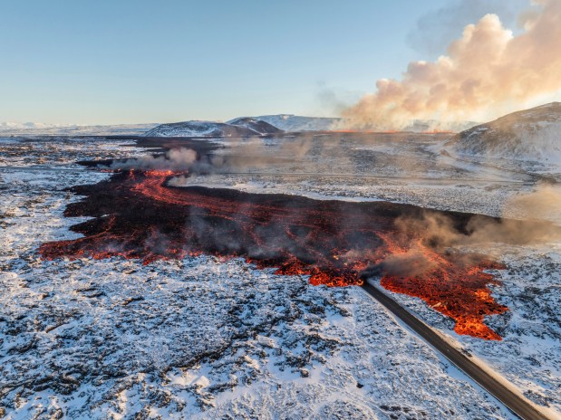 A view of lava crossing the main road to Grindavxc3xadk and flowing on the road leading to the Blue Lagoon, in Grindavxc3xadk, Iceland, Thursday, Feb. 8, 2024. A volcano in southwestern Iceland has erupted for the third time since Dec. and sent jets of lava into the sky. The eruption on Thursday morning triggered the evacuation the Blue Lagoon spa which is one of the island nationxe2x80x99s biggest tourist attractions. (AP Photo /Marco Di Marco)